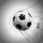 Soccer Football In Goal Net With The Sky Field Stock Photo