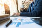 Business Man Working At Office With Laptop, Tablet And Graph Dat Stock Photo