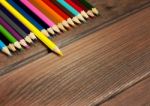 Multicolored Pencils On A Background Of Dark Wood Tables Stock Photo