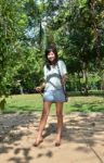 Woman Is Standing On A Swing In A Park Setting Stock Photo