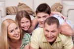 Smiling Family Lying Together On The Floor Stock Photo