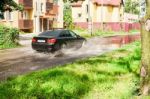 Car Riding On Big Puddle On The Road Stock Photo