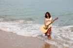 Young lady Playing Guitar at Beach Stock Photo