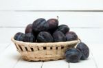 Tasty Purple Plums Isolated On A White Wooden Background Stock Photo