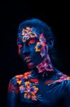 Beautiful Flowers In Uv Light On A Young Girl Face And Body Stock Photo