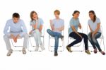 Teenage Friends Sitting On Chairs Stock Photo