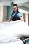 Lady Attendant Arranging Bed Sheet Stock Photo