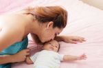 Young Mother Kissing Her Small Newborn Stock Photo