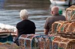 Two People Sitting On The Quayside At Dunbar Stock Photo