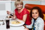 Little Girl Enjoying Dinner With Her Mom Stock Photo