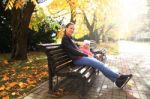 Young Women And Her Daughter Sitting On Bench Stock Photo