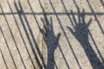 Silhouette Of Prisoner Hands In Jail Stock Photo