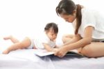 Mother Is Reading A Book For Her Baby Stock Photo