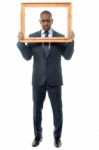 Man Holding Wooden Picture Frame, Looking Down Stock Photo