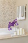 Glass Vase Of Flower On Bath Tub With Towel Hanging Stock Photo