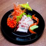 Squid Sashimi In Black Plate On Wood Table Stock Photo