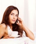 Woman Making Phone Call In Bed Stock Photo