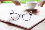 Open Blank White Notebook And Eyeglasses With Cup Of Coffee Stock Photo