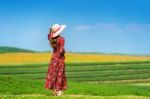 Woman Standing On Green Grass In Green Tea Field Stock Photo