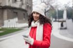 Beautiful Woman In Red Coat And Wool Cap And Gloves With Smartph Stock Photo