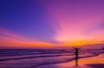 Silhouette Of A Man On The Beach At Twilight Stock Photo