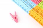 Pink Peg In Front Of Pegs Row From Upper On White Background Stock Photo