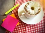 Coffee Cup On Table With White Daisy And Sticky Note, Pen Stock Photo