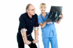 Surgeon Showing X-ray Sheet To Her Patient Stock Photo