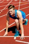 Young Male Sprinter In Starting Blocks Stock Photo