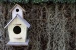 Wood Bird House On Dry Grass And Green Leaf Background Stock Photo