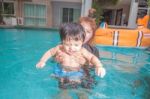 The Kid And Mom Play Together In The Pool Stock Photo