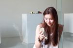 Portrait Of Thai Adult Beautiful Girl Using Her Smart Phone And Smile Stock Photo