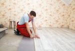 Handyman Laying Down Laminate Flooring Boards Stock Photo