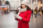 Woman In Red Coat And Wool Cap And Gloves With Smartphone In Han Stock Photo