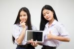 Two Asia Thai High School Student Uniform Best Friends Beautiful Girl Using Her Tablet And Funny Stock Photo