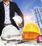 Engineer Working Table Against Sky Scrapper In Urban Scene Use For Land Development And Architecture Occupation Theme Stock Photo