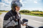 Man Motorcyclist In Protective Helmet Looking At Smartphone Disp Stock Photo