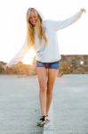 Beautiful Blonde Girl Balancing On A Curb In The City Stock Photo