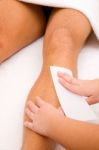 Close-up Of Therapist Waxing Man's Leg Stock Photo