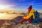 Young Woman Sitting On The Hill Of High Mountains Stock Photo