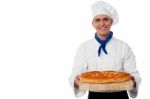 Young Baker Holds A Loaf On Breadboard Stock Photo