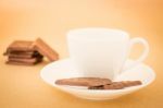 White Mug Of Hot Coffee And Chocolate Pieces Stock Photo