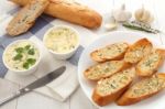 Baguette With Herb Butter And Rosemary Thyme On Rustic Wooden Background Stock Photo