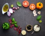 The Ingredients For Homemade Pizza On Dark Stone Background Stock Photo