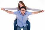 Front View Of A Couple In Piggy Back Ride Stock Photo