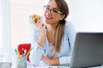 Pretty Young Woman Eating An Apple In Her Office Stock Photo