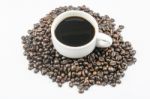 White Cup Of Coffee On Beans Stock Photo