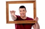 Smiling Young Man With Picture Frame Stock Photo