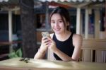 Portrait Of Thai Adult Student University Beautiful Girl Using Her Smart Phone Stock Photo