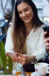 Beautiful Young Woman Using Her Mobile Phone At Cafe Shop Stock Photo